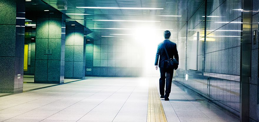 Businessman walking into the light end of tunnel